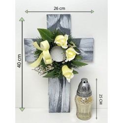 Kríž so sviečkou a umelým kvetom v krémovej farbe.